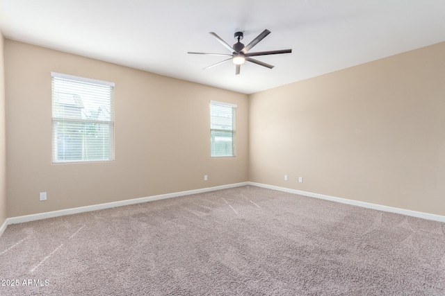 empty room with carpet floors, ceiling fan, and baseboards