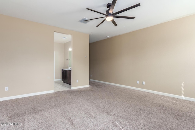 empty room with a ceiling fan, light colored carpet, visible vents, and baseboards