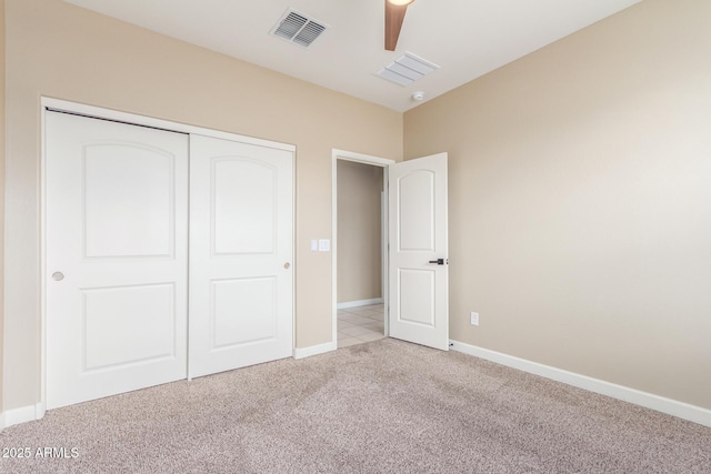 unfurnished bedroom featuring light carpet, baseboards, visible vents, and a closet