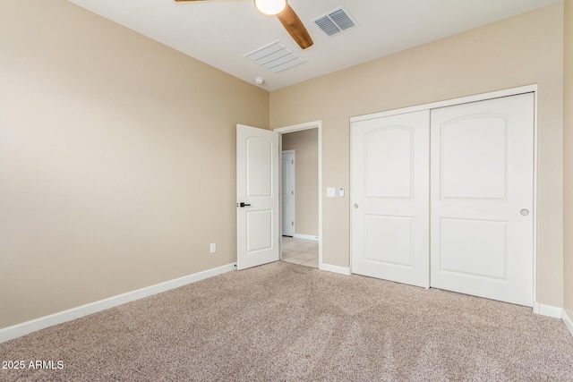 unfurnished bedroom with carpet, a closet, visible vents, and baseboards