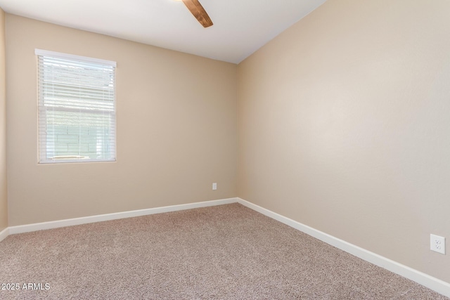 carpeted empty room featuring baseboards and a ceiling fan