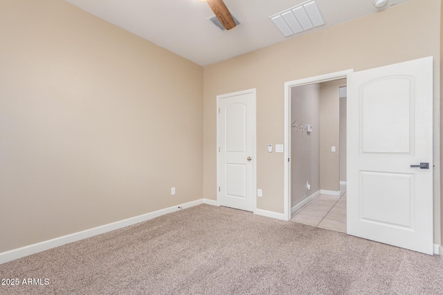 unfurnished bedroom featuring baseboards, visible vents, and light colored carpet