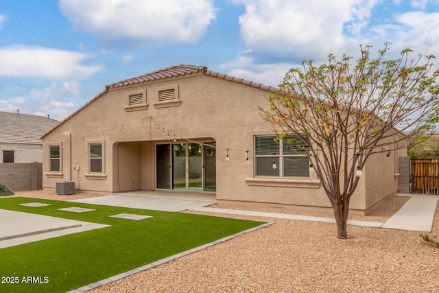 rear view of house with a patio, central air condition unit, fence, a tiled roof, and stucco siding