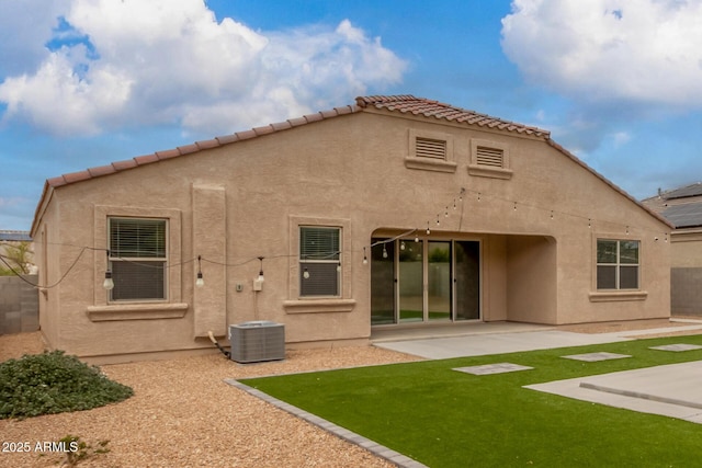 rear view of house with a patio area, a tile roof, and stucco siding