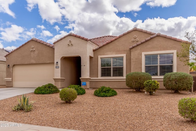 mediterranean / spanish-style house with driveway, an attached garage, a tiled roof, and stucco siding