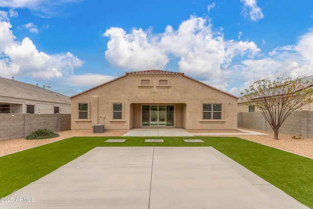 rear view of property featuring a yard, a patio area, a fenced backyard, and stucco siding