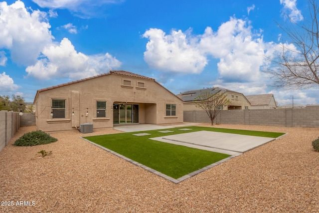 back of property featuring a lawn, a patio, a fenced backyard, a tile roof, and stucco siding