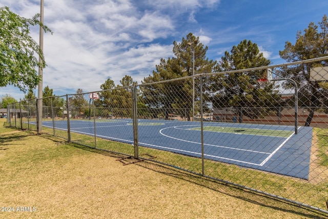 view of sport court with a lawn