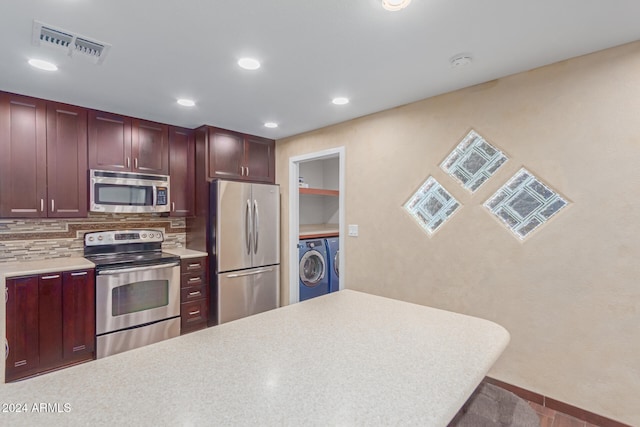 kitchen featuring tasteful backsplash, stainless steel appliances, and washing machine and clothes dryer