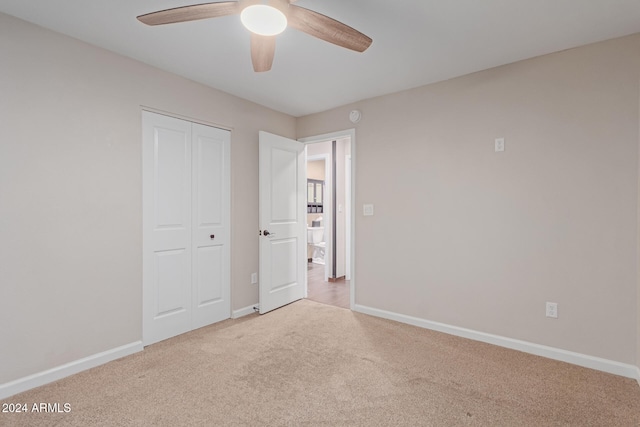 unfurnished bedroom with ceiling fan, a closet, and light colored carpet