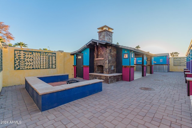 patio terrace at dusk with an outdoor stone fireplace