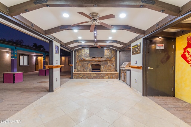 view of patio featuring ceiling fan and a stone fireplace