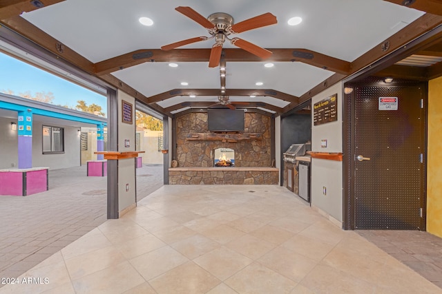 kitchen featuring a breakfast bar, ceiling fan, light tile patterned floors, a fireplace, and butcher block counters