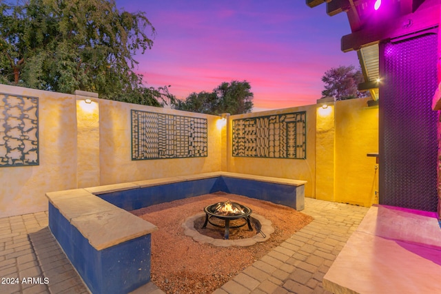 patio terrace at dusk featuring an outdoor fire pit