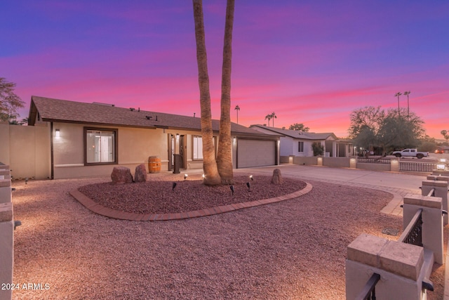 back house at dusk featuring a garage