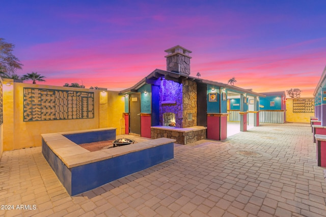 patio terrace at dusk with an outdoor stone fireplace