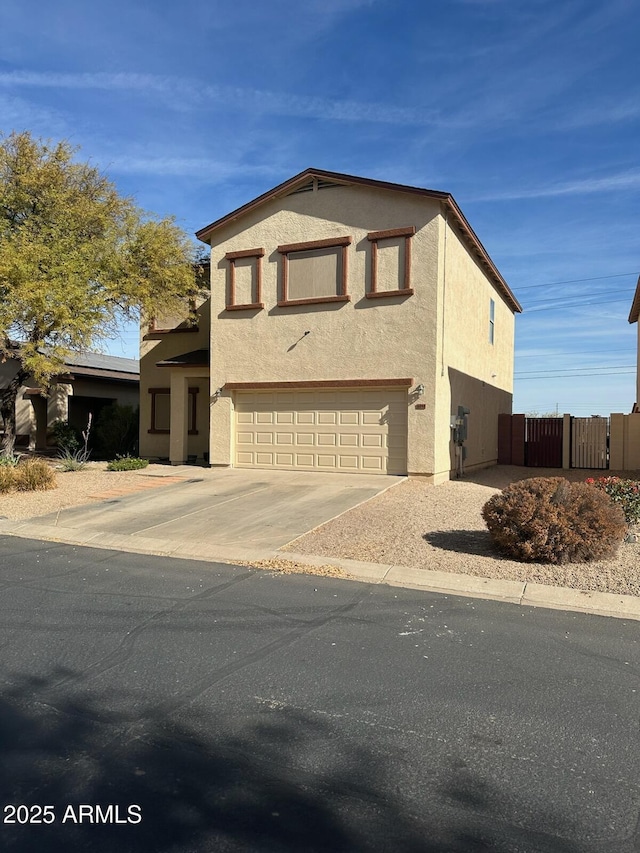 view of front of house with concrete driveway, fence, a garage, and stucco siding