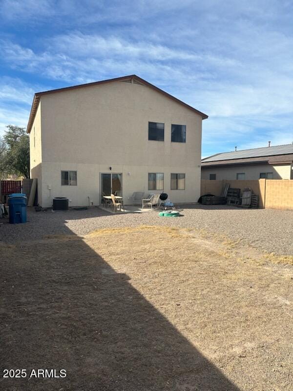 back of house with stucco siding, fence, central AC unit, and a patio area