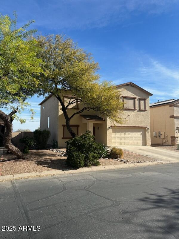 view of front of house featuring concrete driveway, a garage, and stucco siding