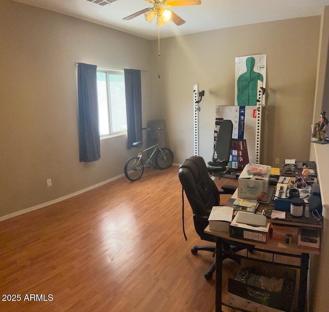 office featuring visible vents, baseboards, wood finished floors, and a ceiling fan