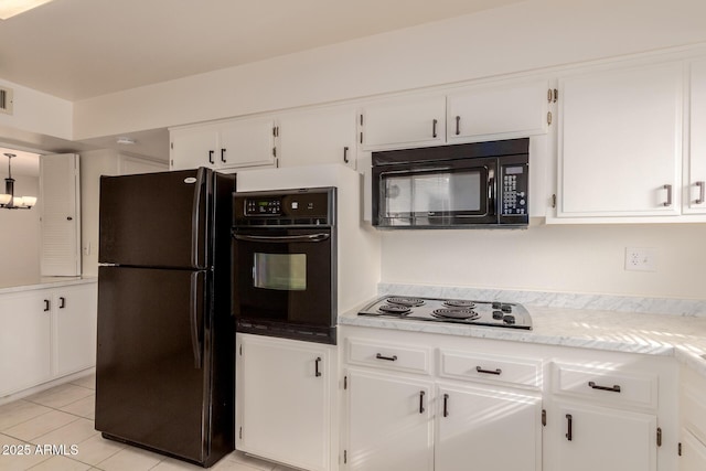 kitchen with light tile patterned floors, white cabinetry, and black appliances