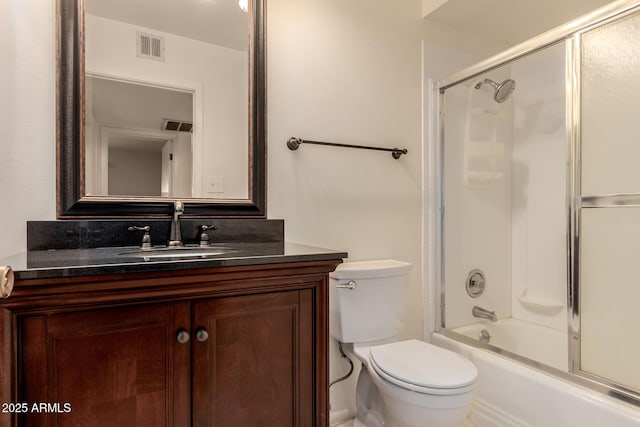 full bathroom with combined bath / shower with glass door, vanity, and toilet