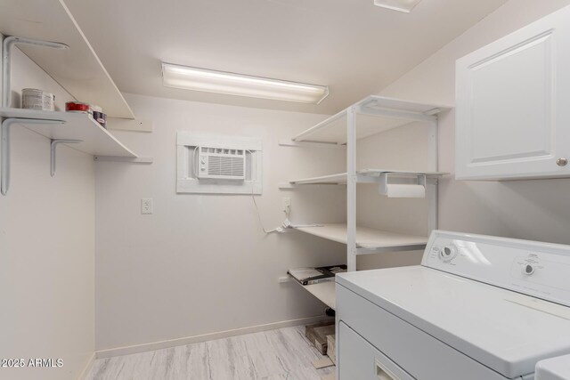 clothes washing area with cabinets, washer / dryer, and a wall mounted AC