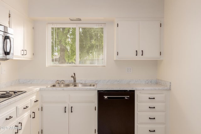 kitchen featuring white gas stovetop, dishwasher, white cabinets, and sink