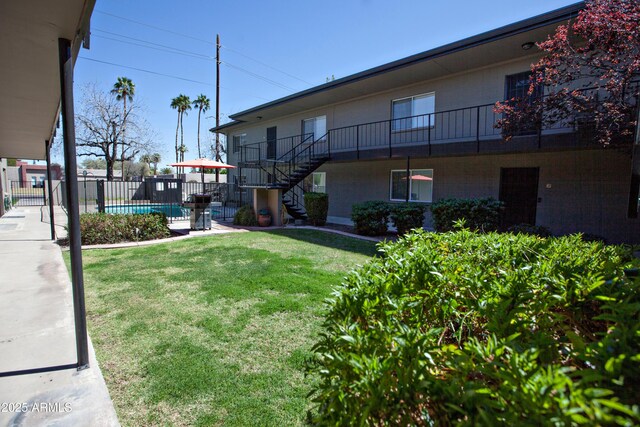 view of yard with a fenced in pool, stairs, and fence