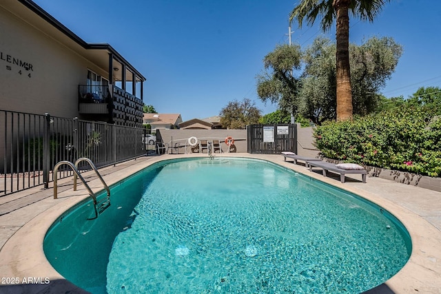 pool with a patio area and fence