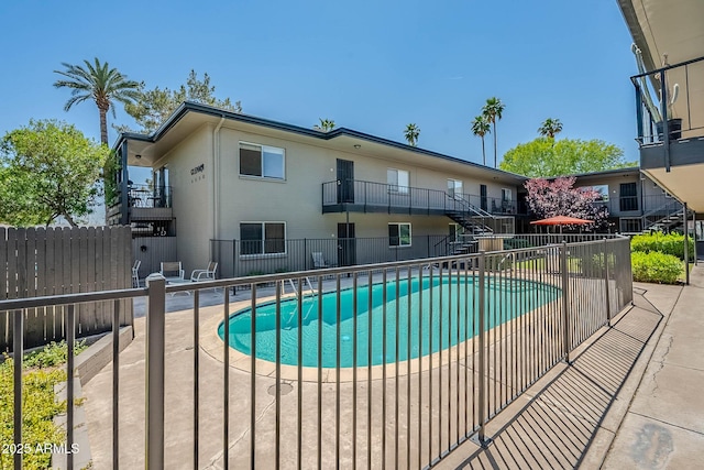 view of swimming pool with a fenced in pool, stairs, and fence