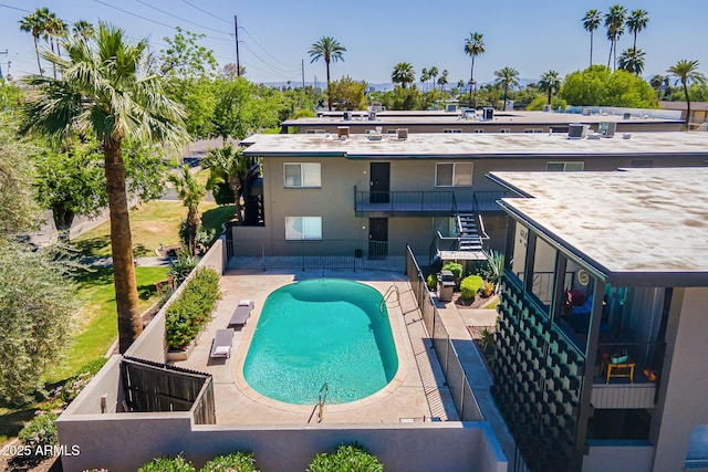 pool featuring stairway, a patio area, and fence