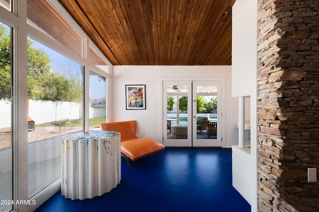 unfurnished sunroom featuring french doors, a water view, and wooden ceiling