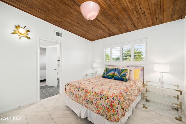 bedroom featuring lofted ceiling, ensuite bathroom, light tile patterned floors, and wooden ceiling