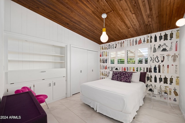 bedroom featuring wood ceiling, a closet, wooden walls, vaulted ceiling, and light tile patterned floors