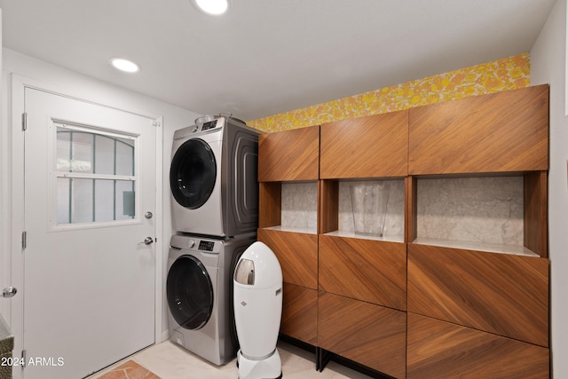 washroom with stacked washer and dryer and light tile patterned floors