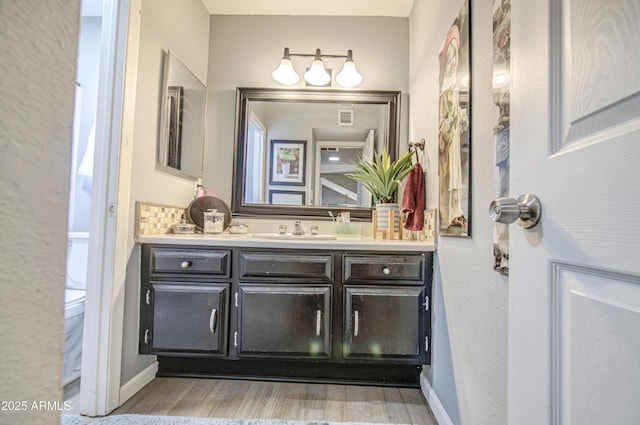 4112 E Maldonado Dr, Phoenix, AZ 85042 - bathroom with vanity, baseboards, visible vents, and wood finished floors