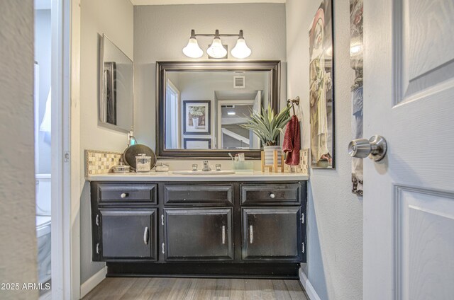 4112 E Maldonado Dr, Phoenix, AZ 85042 - bathroom with vanity, baseboards, and wood finished floors