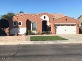 view of front of home with concrete driveway, an attached garage, and stucco siding