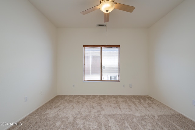 spare room featuring light carpet and ceiling fan