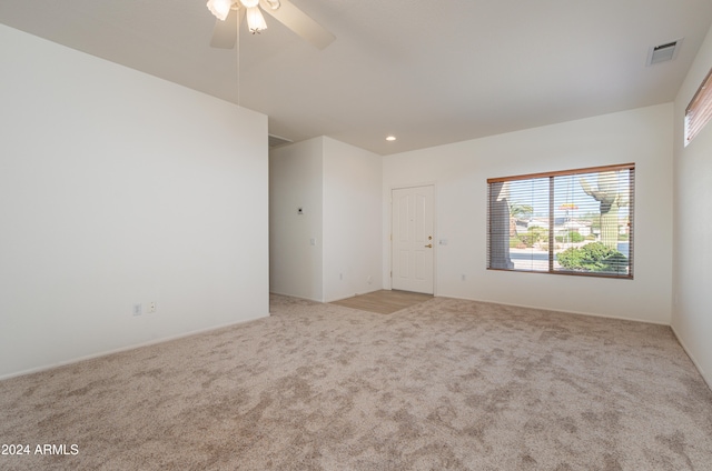 carpeted spare room featuring ceiling fan