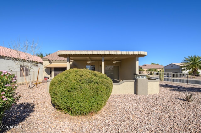 rear view of property featuring ceiling fan