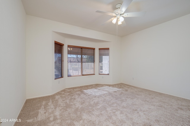 unfurnished room with light colored carpet and ceiling fan