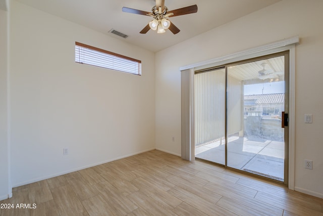 empty room with ceiling fan, a wealth of natural light, and light hardwood / wood-style flooring