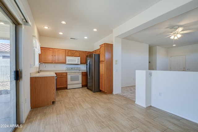 kitchen featuring ceiling fan, sink, light hardwood / wood-style floors, and white appliances