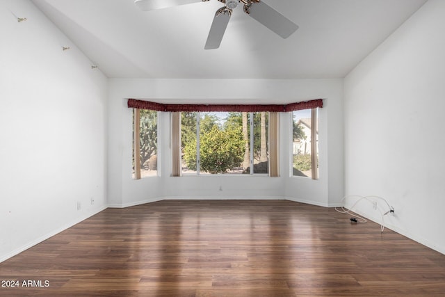 empty room with vaulted ceiling, ceiling fan, and dark wood-type flooring