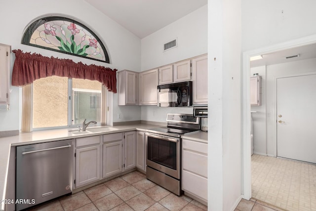 kitchen with sink, high vaulted ceiling, and stainless steel appliances