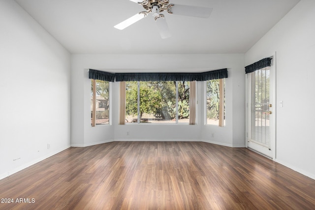 spare room featuring vaulted ceiling, ceiling fan, and dark wood-type flooring