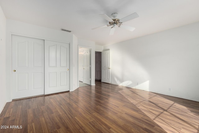 unfurnished bedroom featuring a closet, dark hardwood / wood-style floors, and ceiling fan