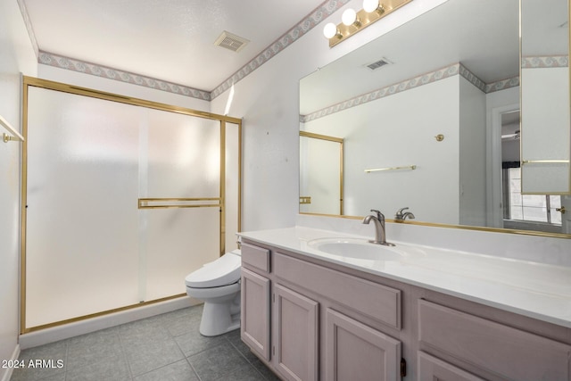 bathroom featuring tile patterned floors, vanity, toilet, and walk in shower